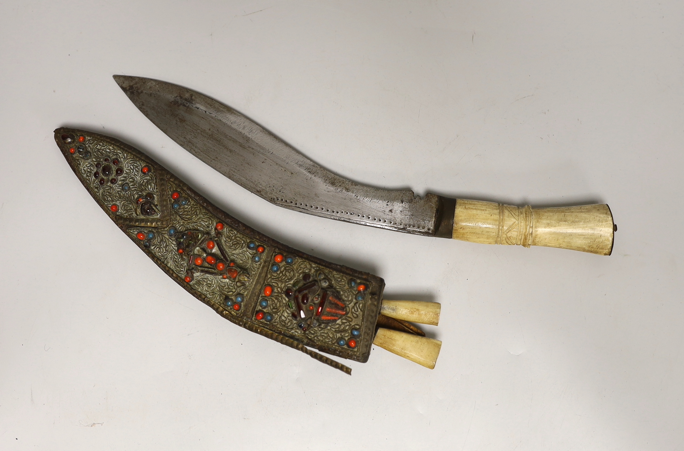 A kukri within white metal mounted sheath, blade 27cm, and three others, one with bone handle